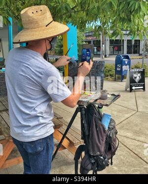 Photographie en couleur du peintre de plein air Jonathan Luczycki peignant une boîte aux lettres potentiellement en danger de disparition à Portland, Oregon août 2020. Banque D'Images