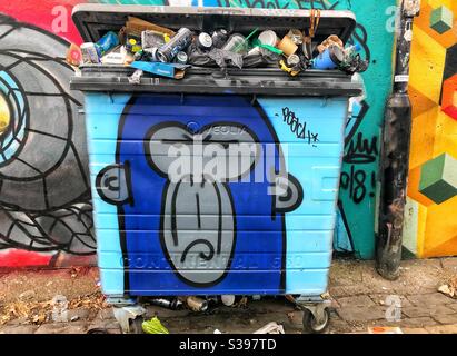 Poubelle à roulettes pleine de déchets ou de déchets et peint avec le graffiti d'un singe en colère dans la rue à l'intérieur Brighton, Royaume-Uni Banque D'Images