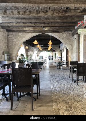 Tables de restaurant installées sous la salle d'arcade de la ville D'Eymet en France Banque D'Images