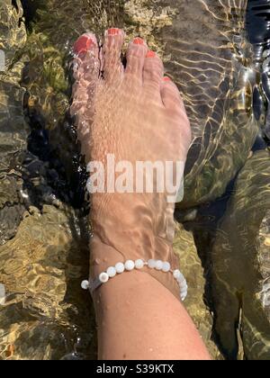 Pied dans l'eau de la rivière avec anklet pearle Banque D'Images