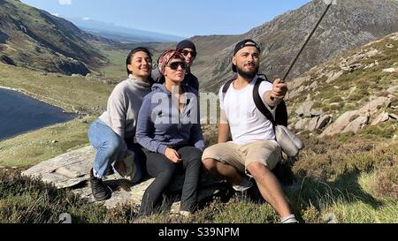 Un groupe d'amis s'empare d'un selfie au sommet d'une montagne à Snowdonia, au pays de Galles. Banque D'Images