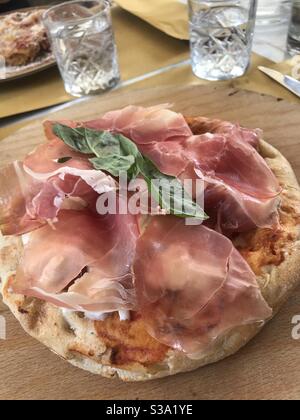 Une grande pizza surmontée de jambon de Parme est servie dans un restaurant de Parme, en Italie Banque D'Images