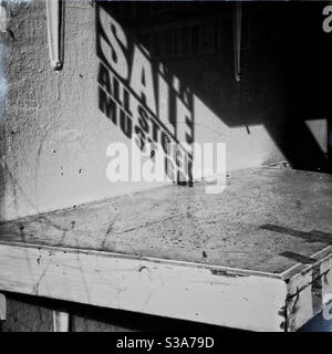 Ombre d’une affiche de vente de liquidation sur les magasins étagère vide Banque D'Images