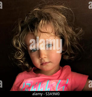 Portrait d'un magnifique tout-petit de quatre ans aux cheveux bruns ondulés et aux yeux voiles. Banque D'Images