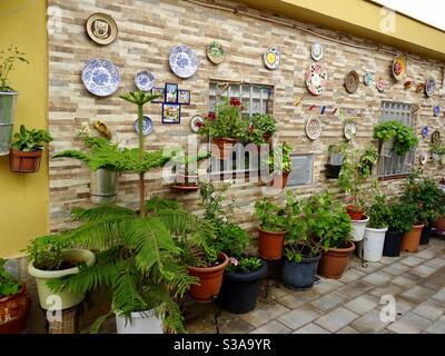 Assiettes décoratives et pots de fleurs sur un mur dans le sud Espagne Banque D'Images