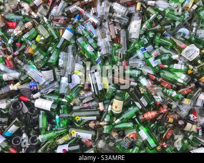 Vider les bouteilles en verre dans un saut de recyclage. Banque D'Images