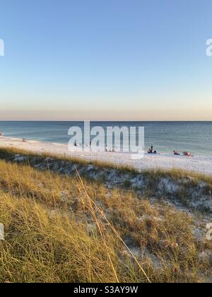 Vue de dessus des gens appréciant un coucher de soleil d'automne sur blanc Plage de sable de Floride Banque D'Images