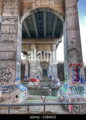 Graffitis sur les piliers d'un pont inférieur. Banque D'Images