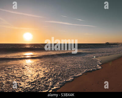 Newport Beach coucher de soleil avec jetée loin dans la distance. Banque D'Images