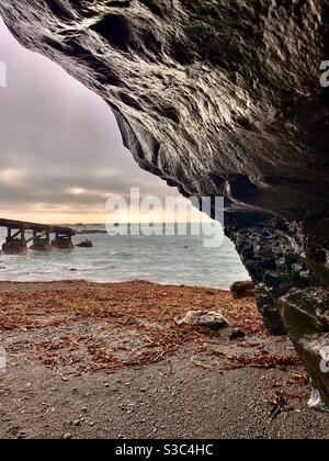 Spectaculaire falaise noire et crique de plage avec jetée s'étendant dans l'océan Atlantique depuis Lizard point, coucher de soleil à Polpeor Cove, Cornwall, Royaume-Uni Banque D'Images