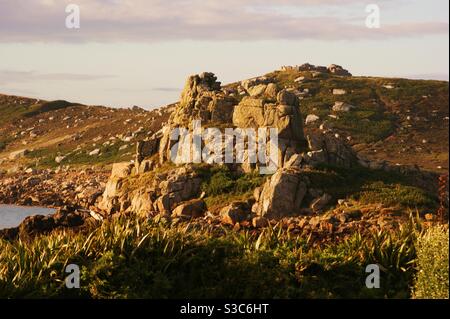 Formation de roches sur la côte de Bryher dans l'île de Scilly, Angleterre au coucher du soleil en été Banque D'Images