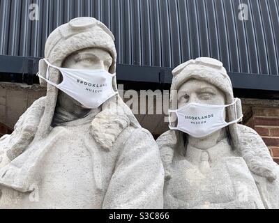 Statues portant des masques COVID-19 au Brooklands Motor Museum. Banque D'Images