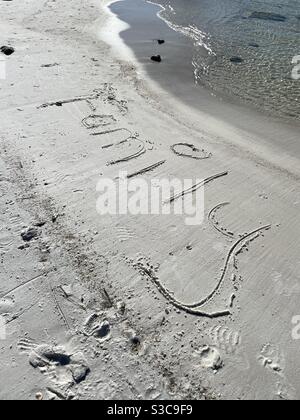 Famille écrite dans le sable sur la plage Banque D'Images