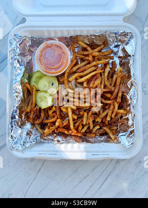 Frites dans un contenant en papier recyclé avec du papier aluminium doublure Banque D'Images