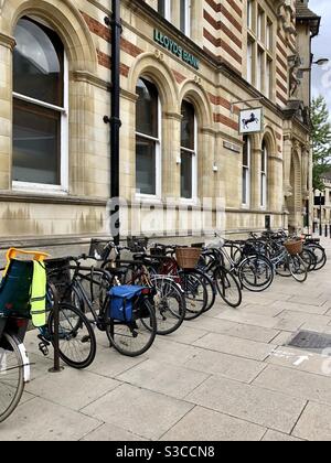 Une rangée de vélos à Cambridge à l’extérieur d’une succursale de Lloyd’s banque Banque D'Images