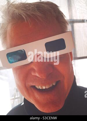 Homme senior portant des lunettes en carton 3-D souriant et regardant l'appareil photo, Etats-Unis Banque D'Images