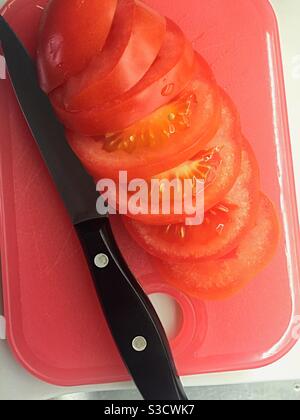 Gros plan d'une tomate fraîchement coupée et d'un couteau à épluchage sur une planche à découper de cuisine résidentielle, États-Unis Banque D'Images