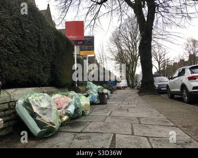 Vue générale sur une rue à Cardiff, pays de Galles, avec des sacs pour la collecte des ordures et des enseignes d'agent immobilier. Banque D'Images