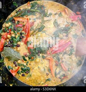 Curry de pois chiches avec feuilles d'épinards et cuisson au poivre rouge dans un pot Banque D'Images