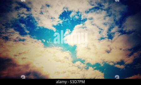 Photographie d'un ciel bleu vif et nuageux aux rayons du soleil. Banque D'Images