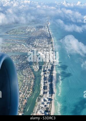 Des nuages blancs moelleux jettent des ombres sur l'eau turquoise de l'océan de Miami Beach, Floride, États-Unis, comme vu d'une fenêtre passager d'un Boeing 737 au départ de l'aéroport international de Miami Banque D'Images