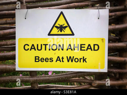 Panneau avertissant les visiteurs de s'attendre à ce que les abeilles travaillent dans le jardin. Parc Wrest, Silsoe, Bedfordshire, Angleterre. Banque D'Images