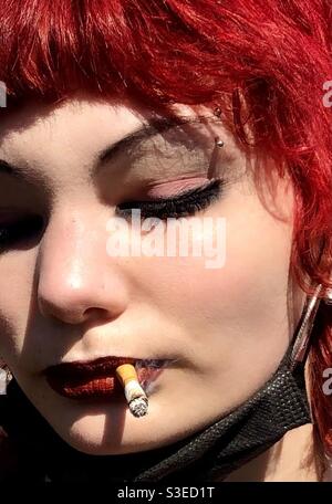 Ado fille punk rouge cheveux fumer Banque D'Images