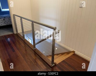Escalier intérieur avec balustrade en acier inoxydable et grille métallique Banque D'Images