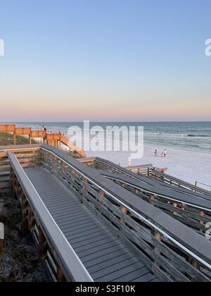 Vue supérieure de la passerelle et les personnes appréciant le coucher de soleil sur blanc Plage de sable à Seaside Florida Banque D'Images