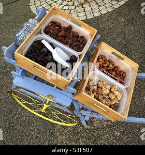 Exposition de fruits secs sur le chariot de l’enfant âgé le jour du marché - France. Banque D'Images