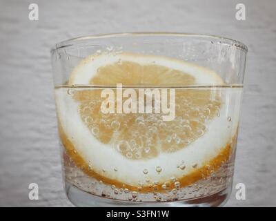 Tranche de citron dans de l'eau pétillante dans un verre Banque D'Images