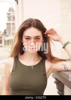 Jolie jeune femme, portrait en plein air avec lumière naturelle. Magnifique brunette portant des lunettes de soleil Street Shoot Banque D'Images
