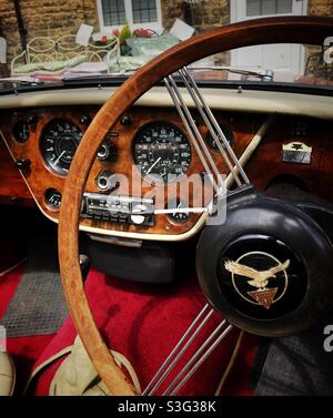 Intérieur d'une voiture classique vintage avec volant en bois et tableau de bord doublé en noyer Banque D'Images