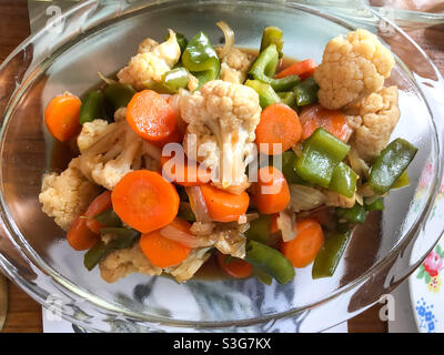 Un bol de légumes sautés mélangés servi dans un bol sur une table. Banque D'Images