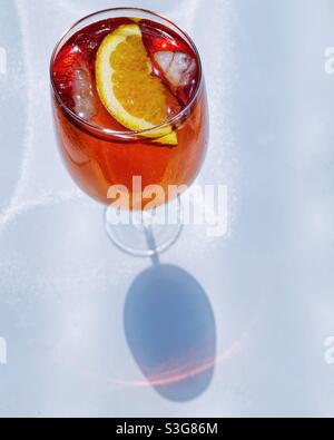 Aperol Spritz extérieur sur une table blanche, d'en haut avec ombre de verre. Banque D'Images