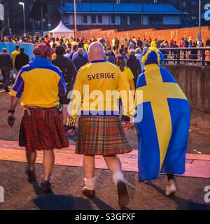Les fans de football portent des hauts de Suède et des fours écossais lors du match Euro 2020 entre la Suède et l'Ukraine au parc Hampden à Glasgow, en Écosse, en juin 2021 Banque D'Images