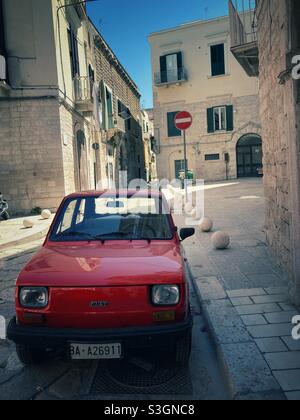 Une voiture rouge dans une rue dans la ville Apulienne de Trani, Italie Banque D'Images