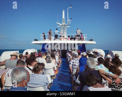 Passagers assis en rangées sur un navire à passagers voyageant vers les îles Tremiti sur la mer Adriatique, Italie Banque D'Images