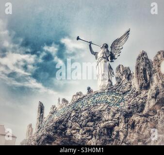 Statue d'ange soufflant la trompette annonçant la naissance du Christ et installée sur une architecture incrustée de pierres précieuses à la Grotte de la Rédemption à West Bend, Iowa Banque D'Images