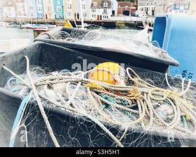 Filets de pêche et flotteurs dans des conteneurs sur le quai d'un port Banque D'Images