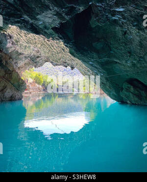 Une photo de l'intérieur d'une grotte en Bosnie jusqu'à la porte avec la lumière qui se reflète sur l'eau Banque D'Images