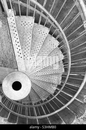 Vue de dessus en noir et blanc d'un escalier en colimaçon métallique Banque D'Images