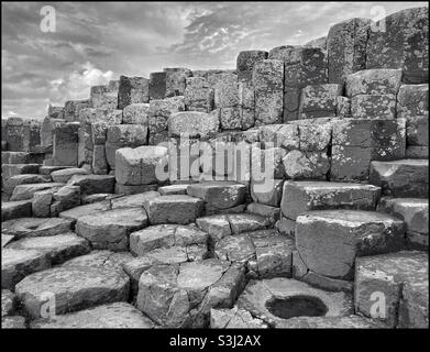Image monochrome de certaines colonnes de basalte qui forment la région connue sous le nom de chaussée des géants en Irlande du Nord.Ce phénomène géologique s'est formé il y a environ 60 millions d'années en raison d'éruptions volcaniques Banque D'Images