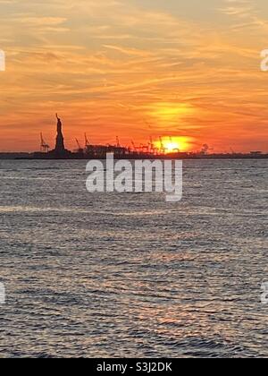 Coucher de soleil à New York sur la Statue de la liberté et réflexion sur l'eau. Prise décembre 2019 Banque D'Images