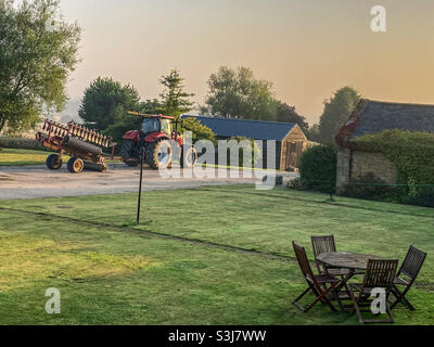 Une moissonneuse-batteuse stationnée à l'extérieur de la ferme de Northumberland après une longue journée en septembre pour retirer le foin et la paille des champs Banque D'Images