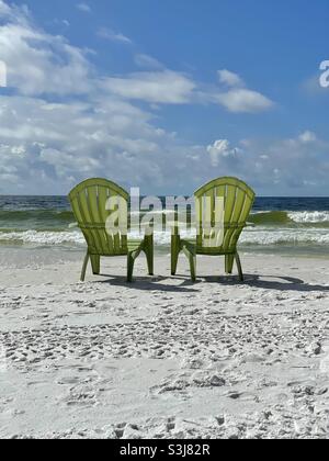 Deux chaises extérieures vertes sur la plage de sable blanc de Floride face à l'eau émeraude du golfe du Mexique Banque D'Images
