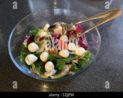 Salade mixte et boules de fromage Mozzarella dans un bol en verre Banque D'Images