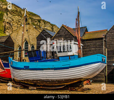 Le bateau de pêche bleu et blanc Grace Georgina devant les cabanes de pêche et le musée des pêcheurs de la vieille ville de Hastings, au Royaume-Uni Banque D'Images