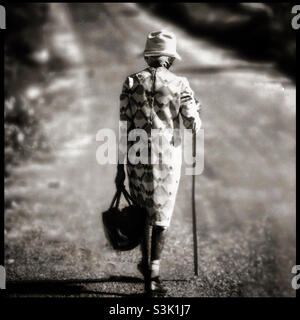 Une femme jamaïcaine âgée marchant en Jamaïque avec un bâton. Banque D'Images