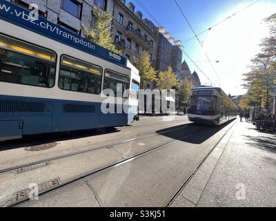 Deux trams passent l'un après l'autre dans des directions opposées sur la rue commerçante principale, Bahnhofstrasse, à Zurich, en Suisse.Atmosphère typique du centre-ville de Zurich. Banque D'Images